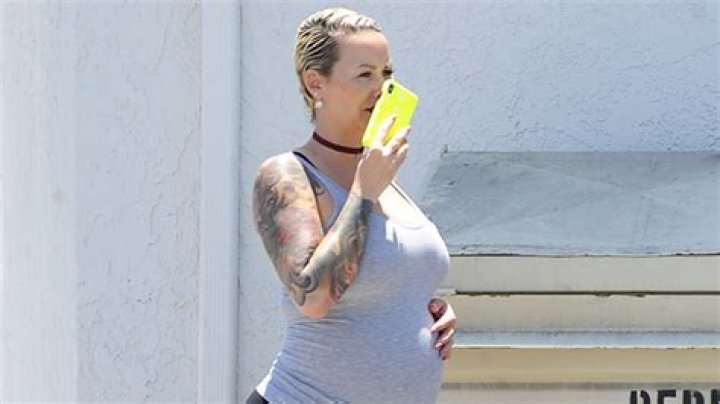 Amber Rose Looks Unrecognizable As She Goes Makeup-Free & Cradles Baby Bump In Skintight Tank Top