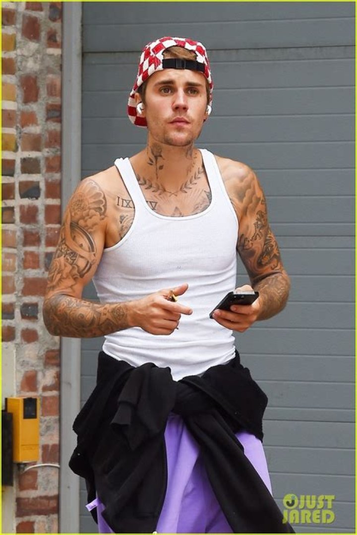 Justin Bieber Shows Off His Tattooed Chest While Lounging Poolside Shirtless With Puppy Oscar