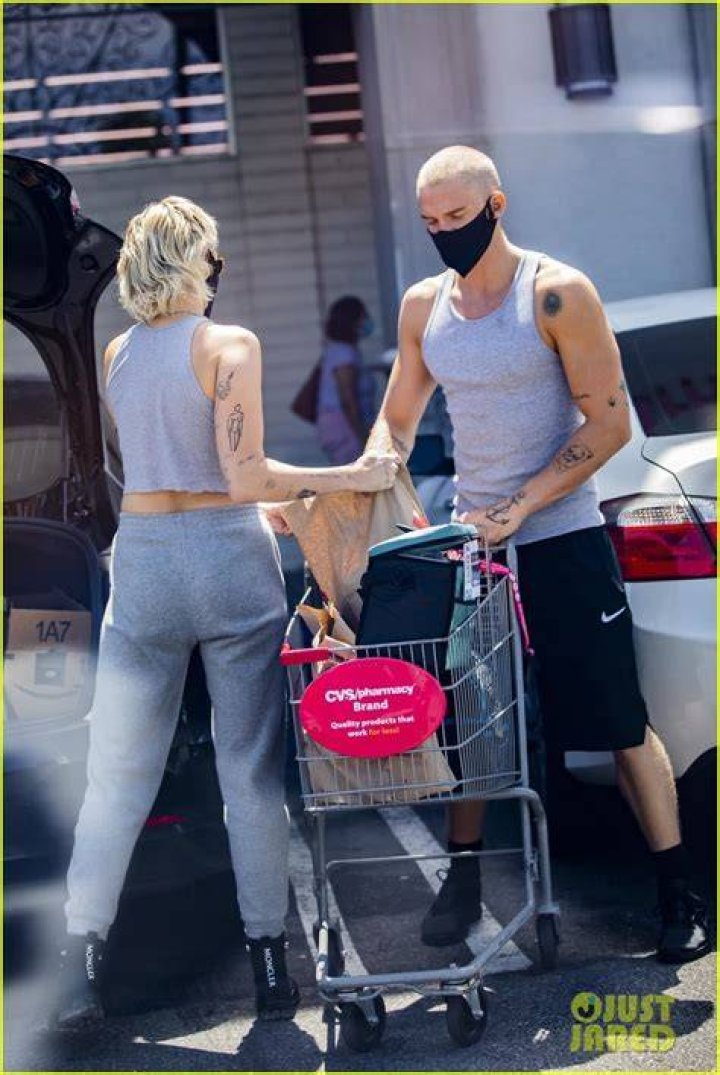 Miley Cyrus & Cody Simpson Twin In Gray Tank Tops & Black Protective Gear As They Leave Grocery Store